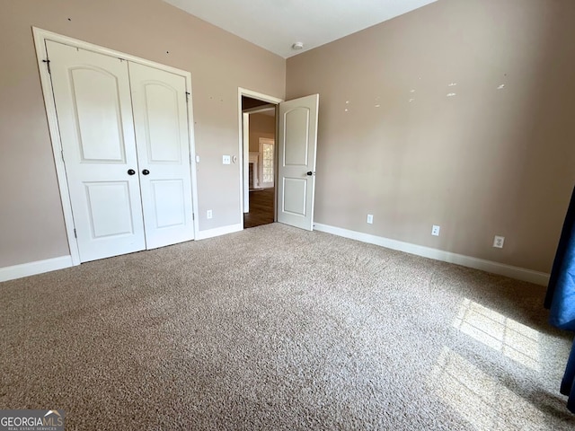 unfurnished bedroom featuring a closet, carpet, and baseboards