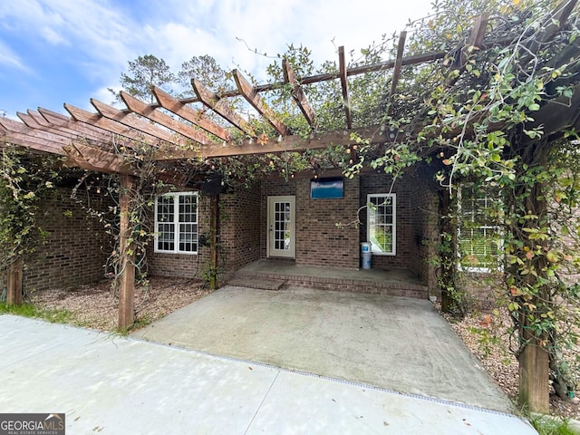 exterior space featuring brick siding, a patio area, and a pergola