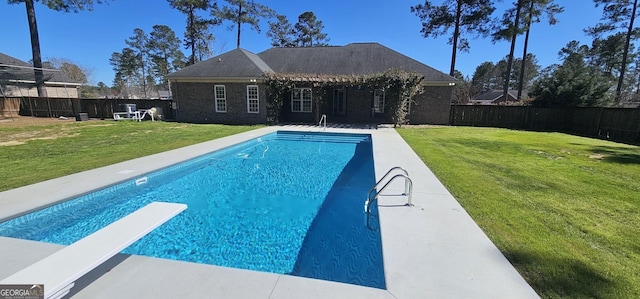 view of swimming pool featuring a diving board, a lawn, a fenced in pool, and a fenced backyard