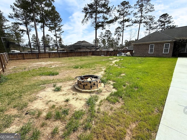 view of yard with a fenced backyard and an outdoor fire pit