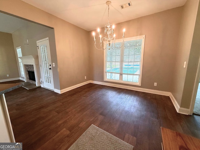 unfurnished dining area with a high end fireplace, visible vents, dark wood-type flooring, and baseboards