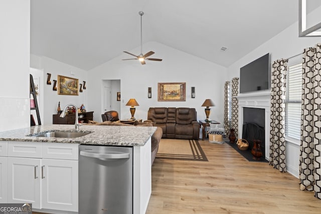 kitchen featuring a sink, white cabinetry, light wood-style floors, a fireplace, and dishwasher