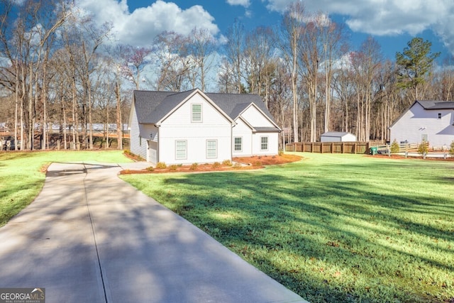 view of front of home featuring concrete driveway, a front yard, and fence