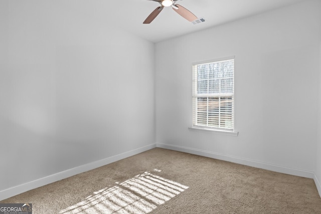 empty room featuring baseboards, visible vents, carpet floors, and ceiling fan