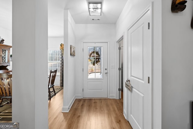 entryway featuring visible vents, baseboards, and light wood finished floors