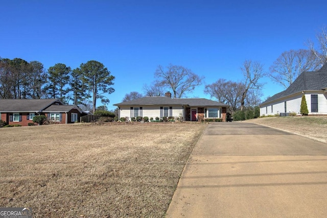 view of front of home featuring a garage, a chimney, and a front yard