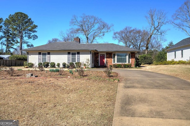 single story home with fence, driveway, and a chimney