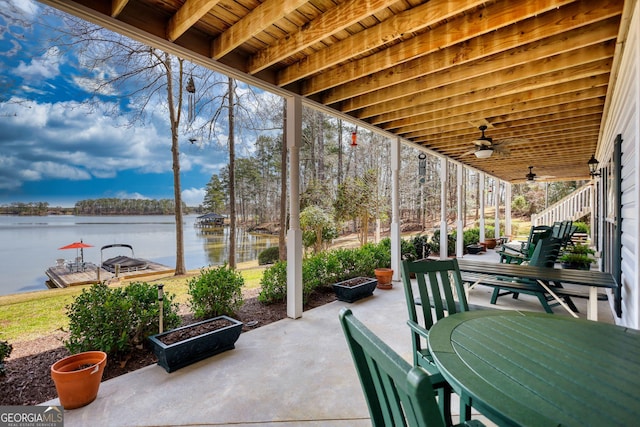 view of patio with outdoor dining area, a ceiling fan, and a water view