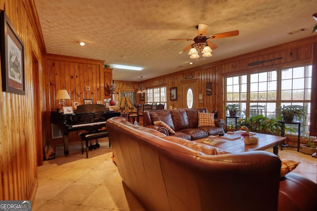 living room featuring wooden walls, visible vents, and a textured ceiling