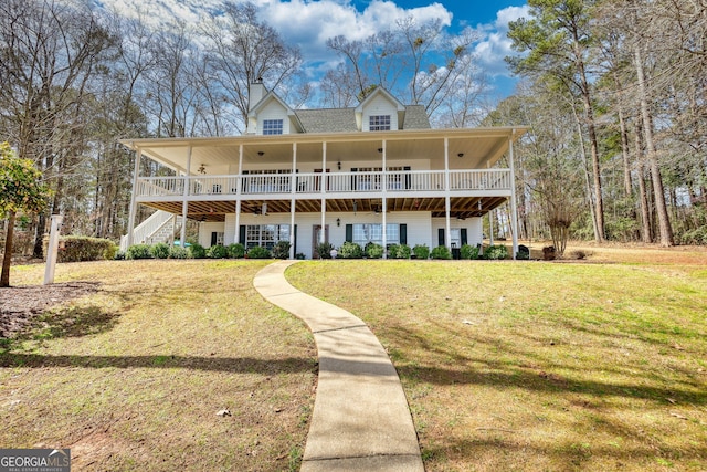 rear view of property featuring a lawn and a chimney