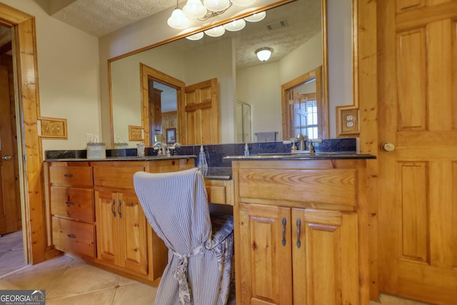 bathroom featuring visible vents, a textured ceiling, vanity, and tile patterned flooring