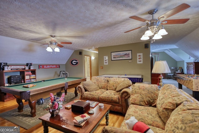 living room with a textured ceiling, wood finished floors, pool table, and vaulted ceiling