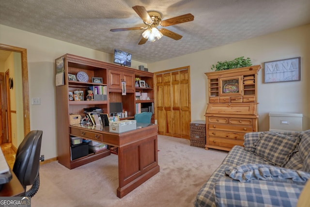 office with light colored carpet, baseboards, a textured ceiling, and a ceiling fan