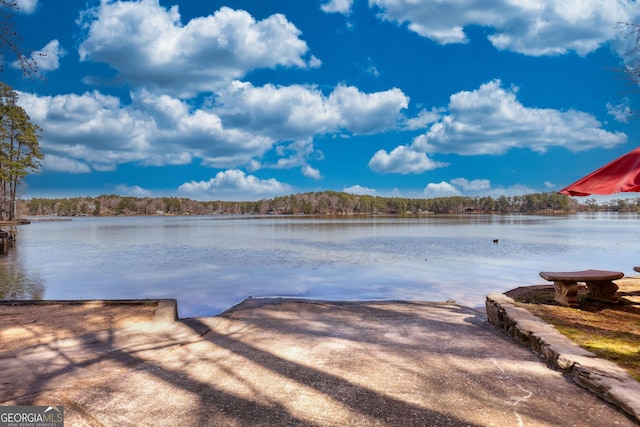 view of dock with a water view and a wooded view