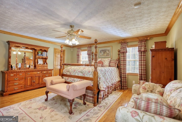 bedroom with light wood finished floors, crown molding, baseboards, ceiling fan, and a textured ceiling