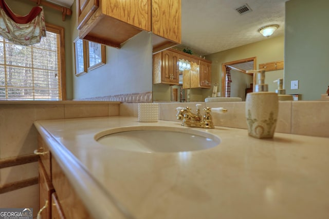 bathroom with visible vents, a textured ceiling, and vanity