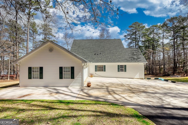 back of house with a shingled roof and a patio