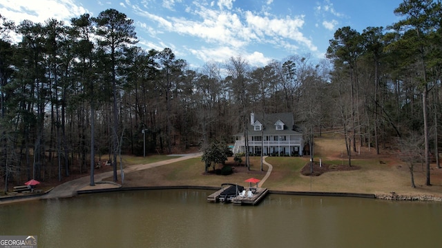 view of dock with a water view and a lawn