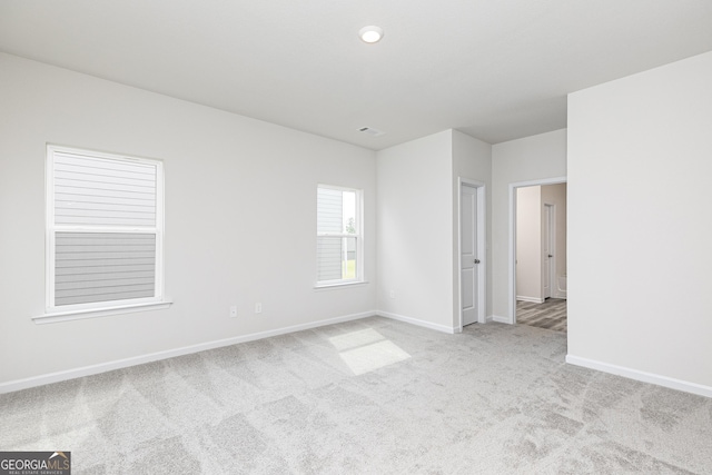 carpeted empty room featuring visible vents and baseboards