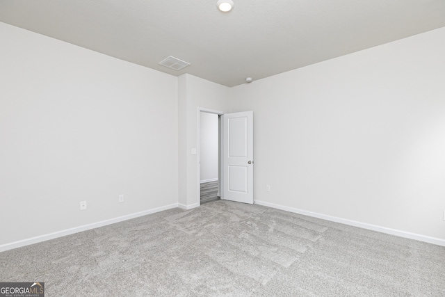 carpeted empty room with visible vents and baseboards