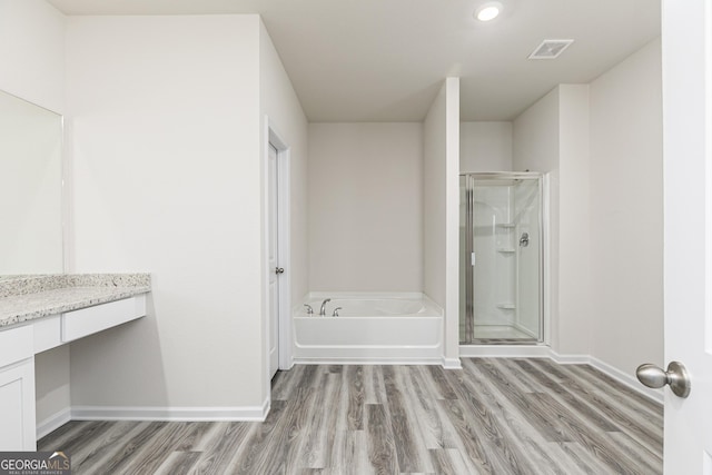 full bathroom featuring visible vents, a shower stall, baseboards, wood finished floors, and a bath