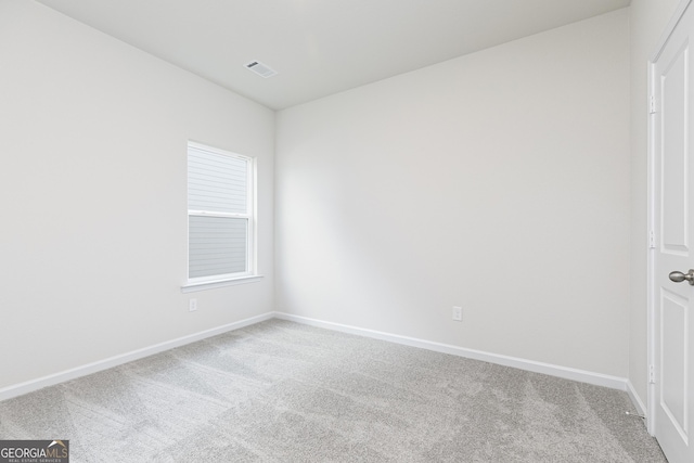 carpeted spare room with visible vents and baseboards