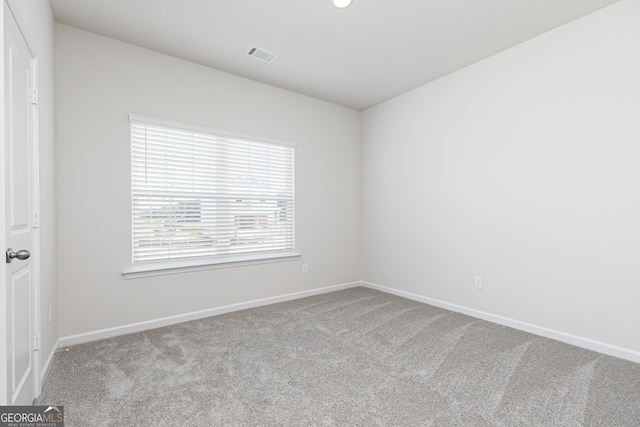 carpeted spare room with baseboards and visible vents