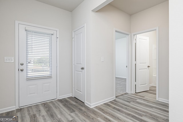 foyer entrance featuring baseboards and wood finished floors