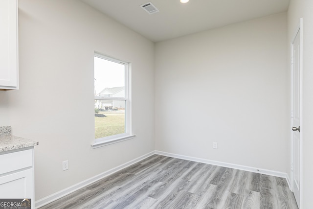 unfurnished dining area with light wood finished floors, visible vents, recessed lighting, and baseboards