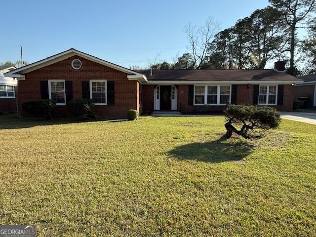 ranch-style home featuring brick siding and a front lawn