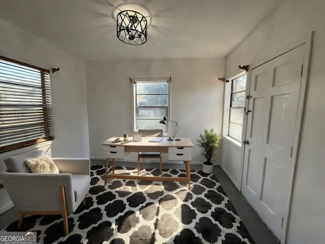 office space featuring an inviting chandelier and baseboards