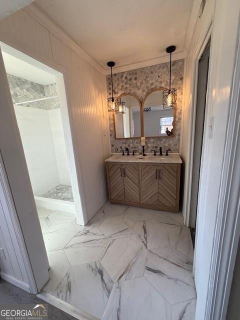 full bath with marble finish floor, a shower stall, crown molding, and double vanity