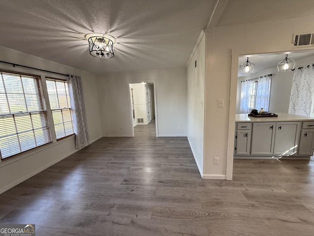 unfurnished room with dark wood-type flooring, a healthy amount of sunlight, and visible vents