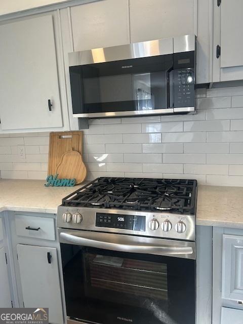 kitchen featuring white cabinetry, light countertops, tasteful backsplash, and appliances with stainless steel finishes