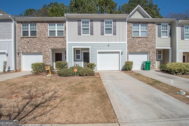 view of property with brick siding, board and batten siding, an attached garage, and driveway