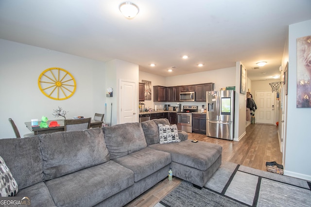 living area with light wood finished floors, recessed lighting, and baseboards