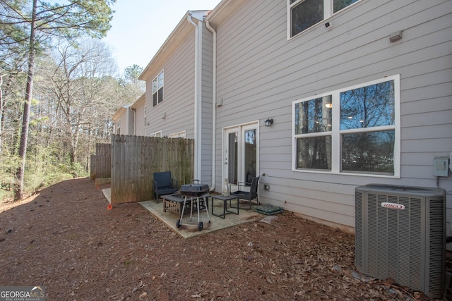 rear view of house with a patio, central AC, and fence