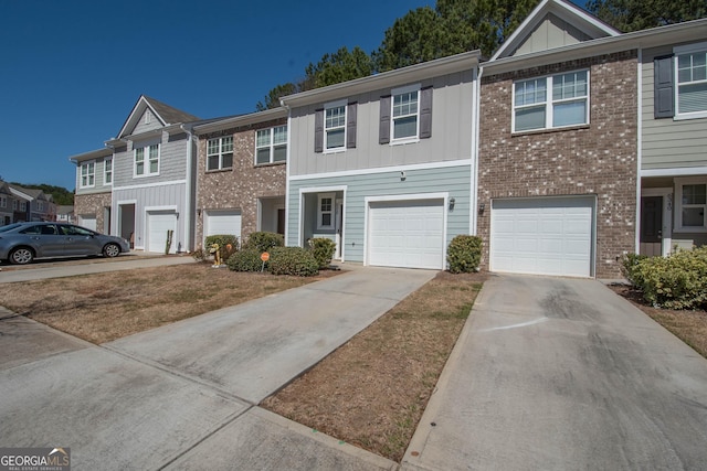 multi unit property featuring a garage, brick siding, board and batten siding, and driveway