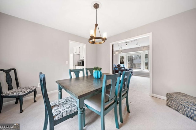 dining area featuring a notable chandelier, baseboards, and light carpet