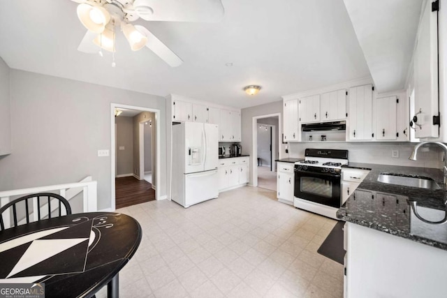 kitchen featuring a sink, under cabinet range hood, white refrigerator with ice dispenser, gas range oven, and light floors