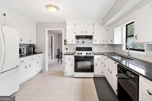 kitchen featuring gas stove, freestanding refrigerator, a sink, dishwasher, and stainless steel microwave