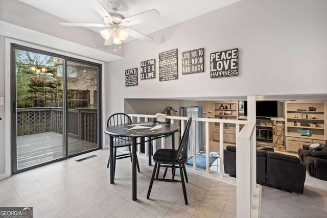 dining room featuring visible vents, ceiling fan, and a fireplace