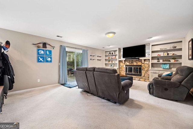 carpeted living room featuring visible vents, baseboards, built in shelves, and a fireplace