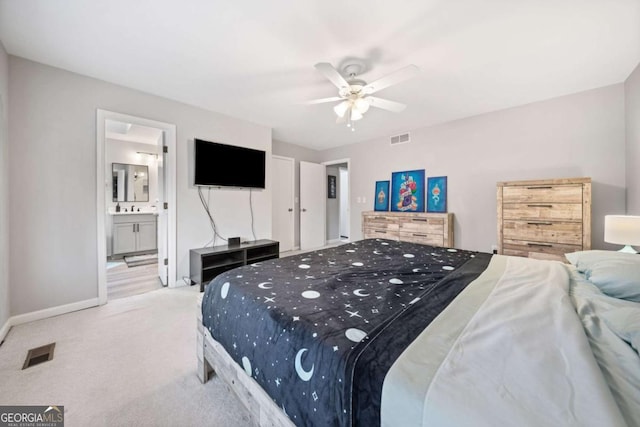 bedroom with connected bathroom, light colored carpet, visible vents, and baseboards