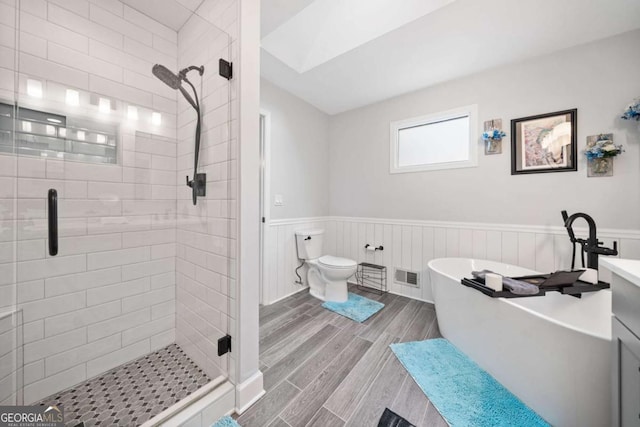 full bath with a wainscoted wall, a stall shower, visible vents, and wood tiled floor