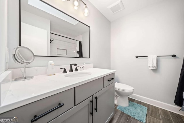 full bathroom featuring visible vents, baseboards, wood tiled floor, toilet, and vanity