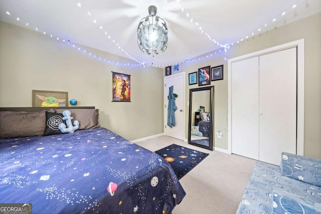 carpeted bedroom featuring a closet and baseboards