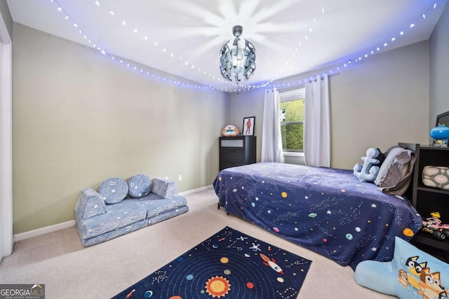 carpeted bedroom featuring an inviting chandelier and baseboards