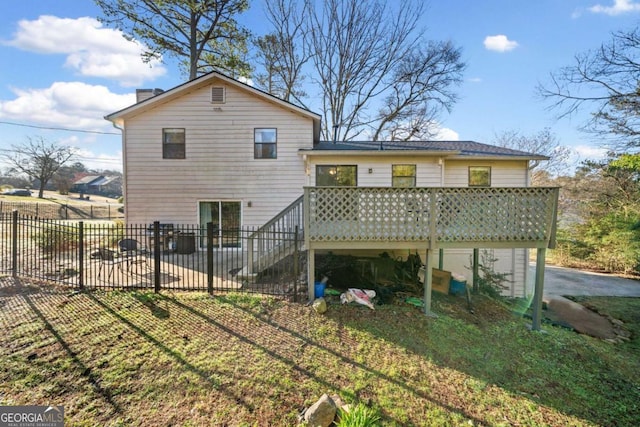 back of property with stairway, a deck, and fence