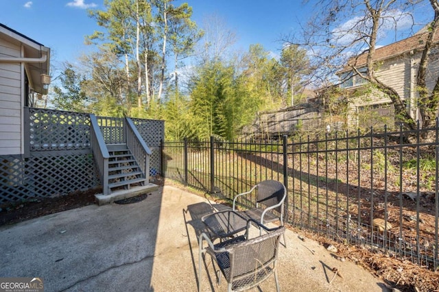 view of patio featuring stairway, a wooden deck, and fence